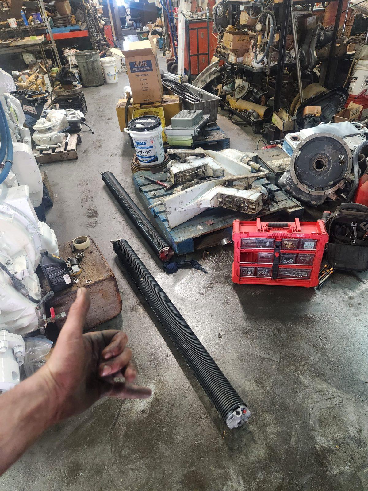 Snapped garage door torsion spring removed at an auto shop