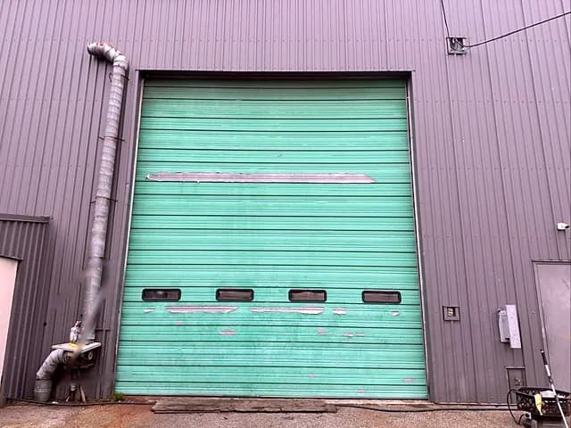 Green industrial sectional overhead door on a warehouse